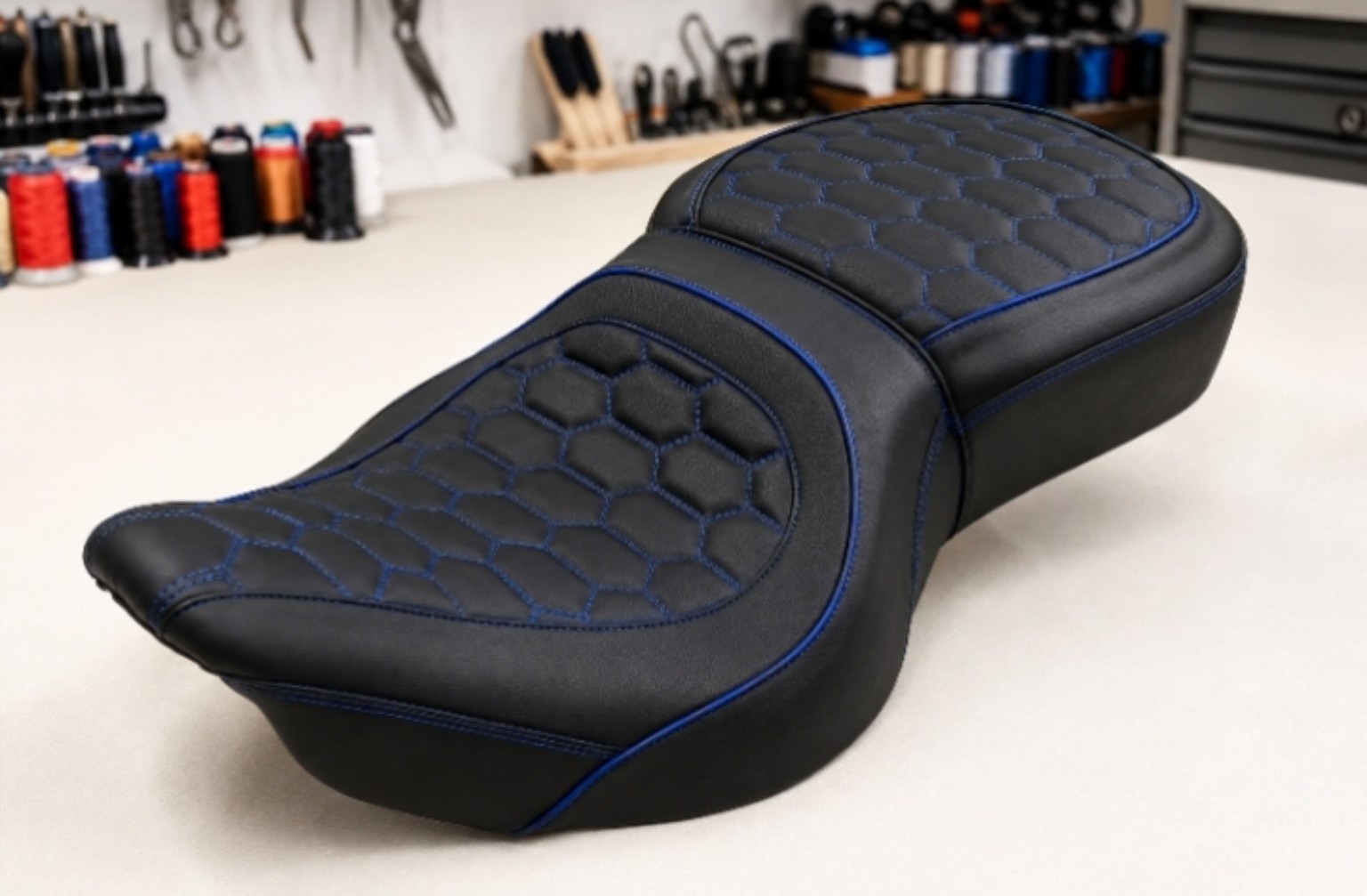 Black custom motorcycle seat with blue hexagon stitching